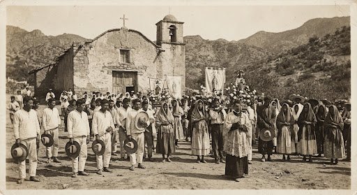 Fotografía histórica en sepia de una procesión de la comunidad en los primeros años del siglo XX.